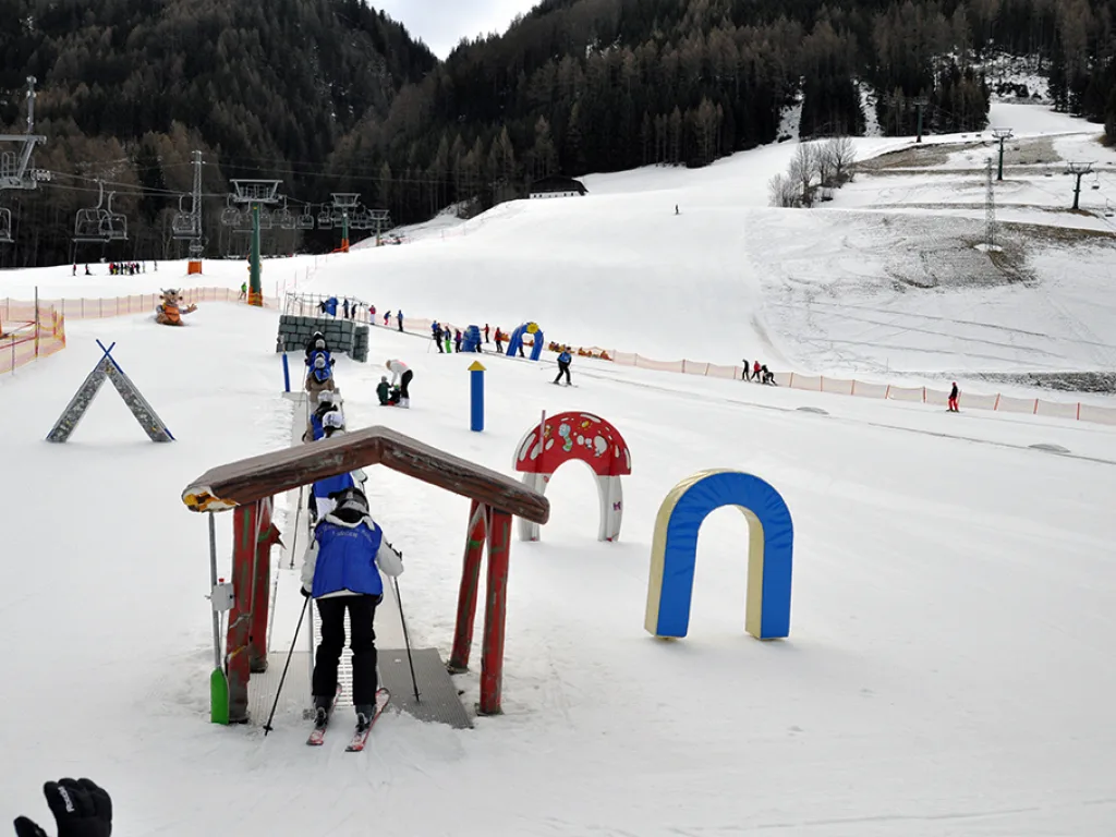 Übungsparcours mit Holztor und blauem Bogen auf der Piste.